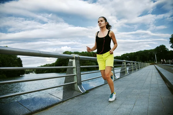 Docela sportovní žena jogging v parku — Stock fotografie