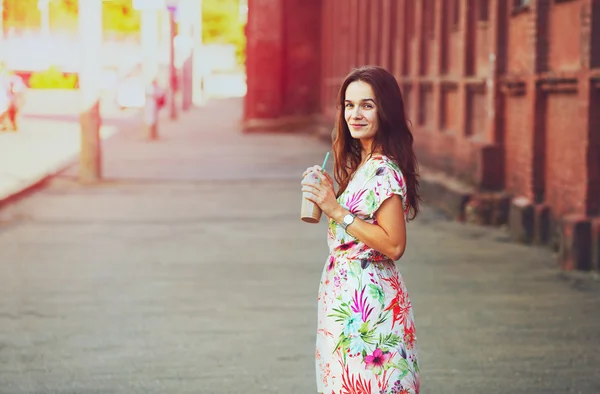 Bonita chica sonriente con batido de leche caminando en la calle de la mañana — Foto de Stock