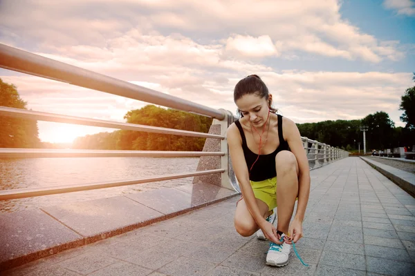 Deportiva chica preparándose para el entrenamiento y trotar en el parque de atar —  Fotos de Stock