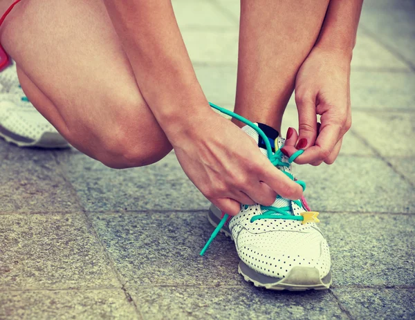 Meisje klaar voor opleiding en joggen in het park koppelverkoop schoenen — Stockfoto