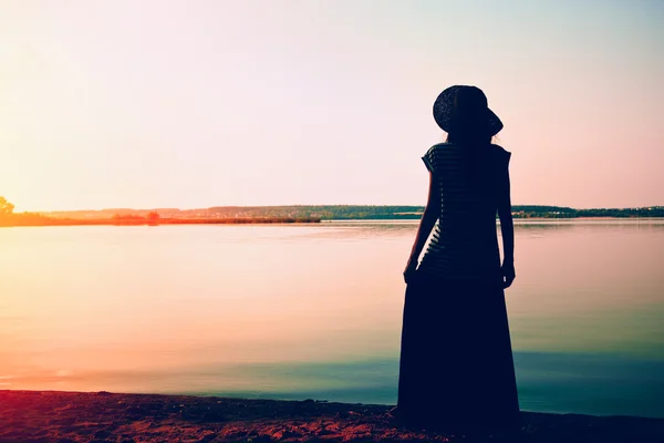 Silhouette femme debout seul sur la côte de la mer et regardant wate — Photo