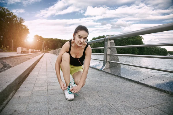 Menina desportiva se preparando para treinar ang jogging no parque amarrando — Fotografia de Stock