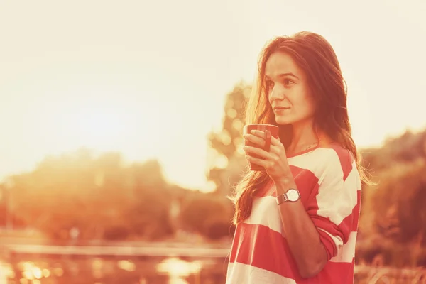 Pretty girl with morning coffee at river sunrise — Stock Photo, Image