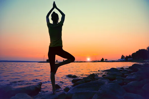 Siluett av kvinna utövar yoga — Stockfoto