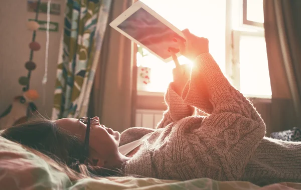 Женщина в постели с цифровым планшетом — стоковое фото