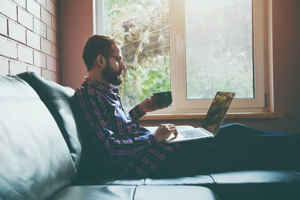 Bebaarde man met laptop — Stockfoto