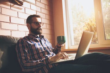 Laptoplu bir adam kahve içiyor.
