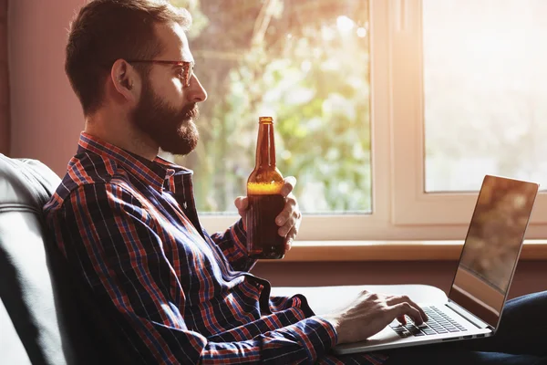 Man with laptop and beer — Stock Photo, Image
