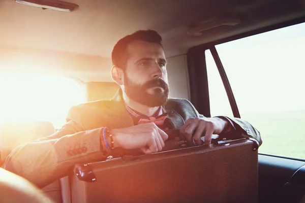 Hombre de negocios sentado en el asiento trasero del coche — Foto de Stock