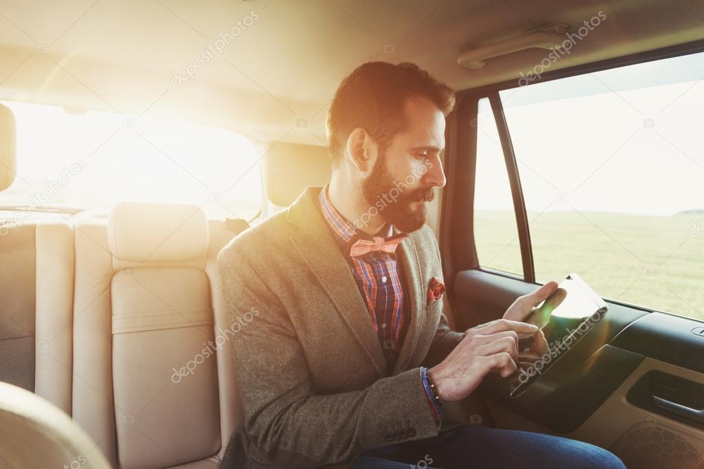businessman sitting on back seat of car