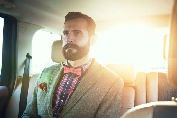 Businessman on back seat of car — Stock Photo, Image