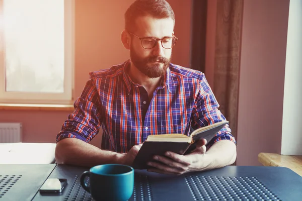 Skäggig man läser bok — Stockfoto