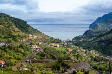 Madeira Adası, serpantin dağ yolu, tipik peyzaj dağlar ve okyanus manzaralı evler