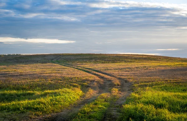 Luz del atardecer en la carretera de campo. Belarús . — Foto de Stock