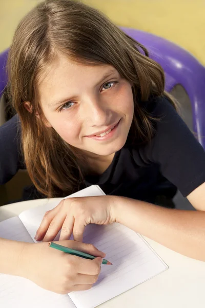 Smiling child writes — Stock Photo, Image