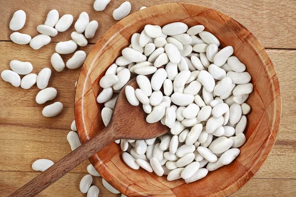 Frijoles blancos en una tabla de madera —  Fotos de Stock