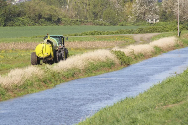 Tractor y canal de agua de riego —  Fotos de Stock