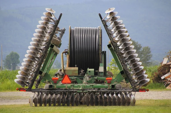 Ein Pflug rahmt eine Bewässerungsrolle ein — Stockfoto