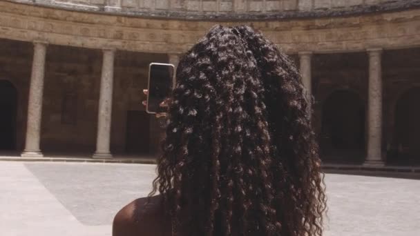 Молодой черный турист со смартфоном во дворе Альгамбра — стоковое видео