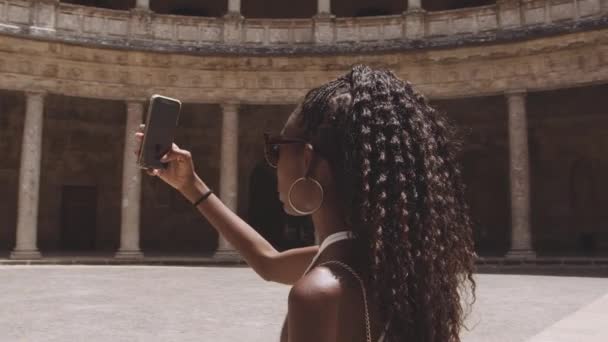 Svart turist med smartphone i Alhambra gård — Stockvideo