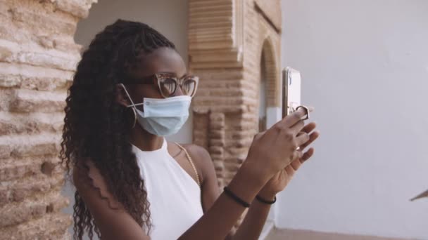 Mujer joven en máscara demandando Smartphone en el Palacio de la Alhambra — Vídeos de Stock