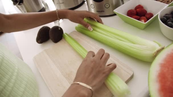 Vrouw zetten selderij in keuken blender — Stockvideo