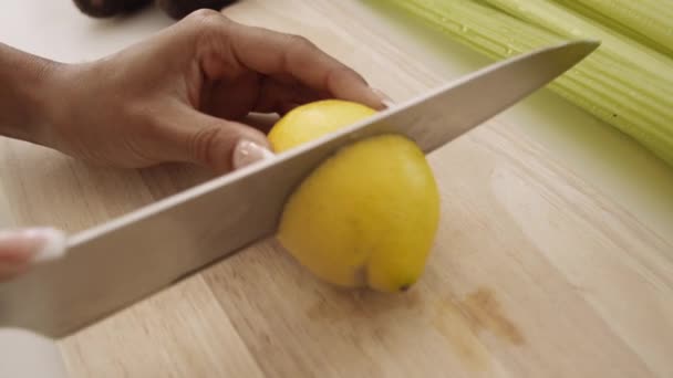 Kobieta krojenie cytryny z nożem do sokowirówki — Wideo stockowe