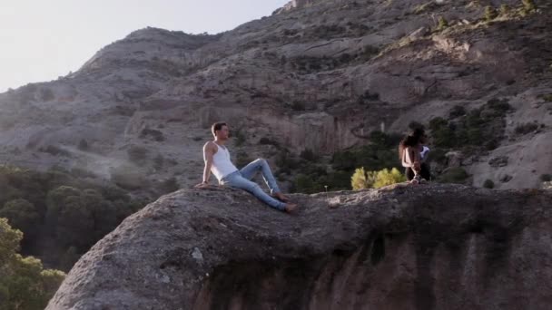 Молода пара відпочиває на скелях в Іспанії — стокове відео