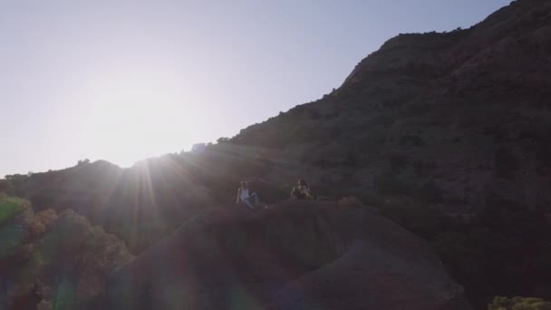 Молода пара розслабляється на скелях у сонячному — стокове відео