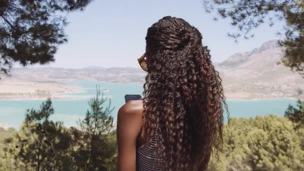 Чорна жінка користується смартфоном в Іспанії — стокове відео