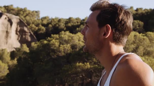 Красивый молодой человек улыбается в испанском пейзаже — стоковое видео