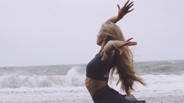 雨の中、美しいダンサーがブラックビーチで踊る — ストック動画