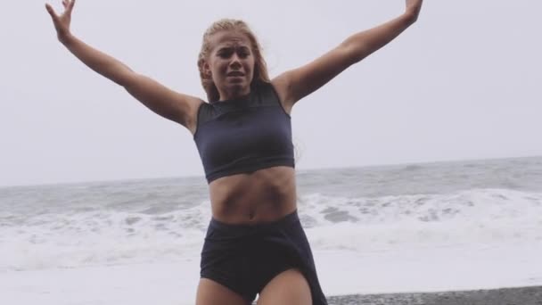 Woman with Arms Stretched as She Dances in Black Beach on a Rainy Day — Stock Video