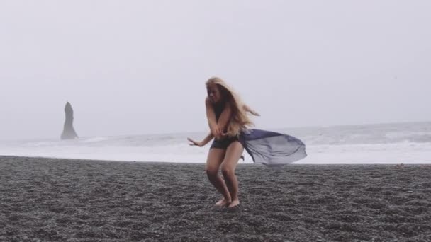 Appassionato giovane ballerino dalla spiaggia nera in una giornata ventosa — Video Stock