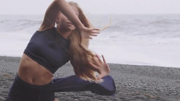 Donna di talento su una spiaggia nera che balla sotto la pioggia — Video Stock