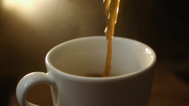 Espresso derramando na taça de porcelana branca e gotas salpicando — Vídeo de Stock