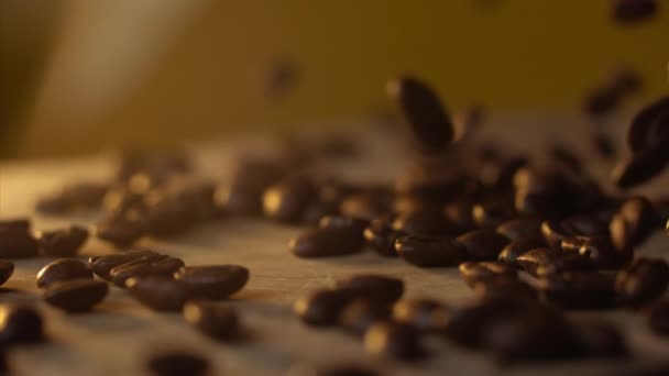 Świeże ziarna kawy spadające na stół w Slowmo — Wideo stockowe