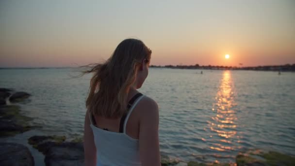 Kvinna tittar på solnedgång från stranden — Stockvideo