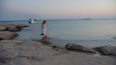 Etek Tutan ve Denizde Yürüyen Kadın