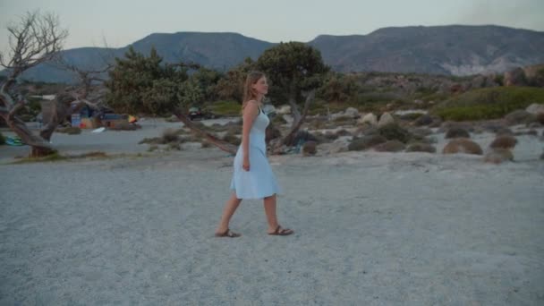 日落时走在沙滩上的女人 — 图库视频影像