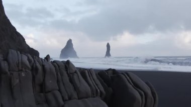 Karanlık çöktüğünde deniz yığınlarıyla Kara Kum Kumsalı