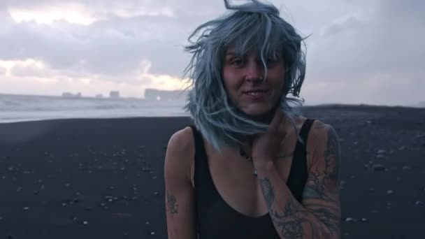 Sonriendo Cool Girl en la playa de arena negra — Vídeo de stock