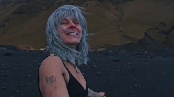 Bella ragazza dai capelli blu sulla spiaggia nera — Video Stock