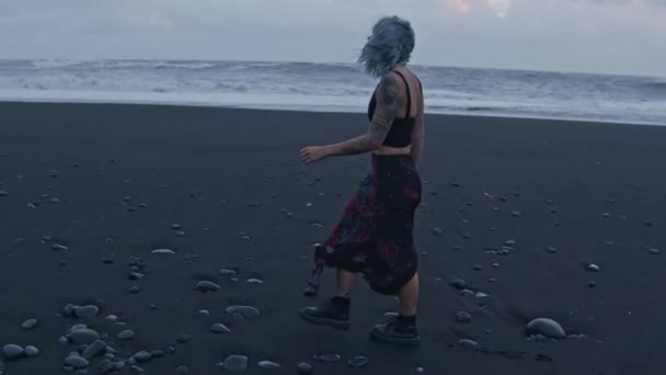 Δροσερό κορίτσι που περπατά σε μαύρη παραλία — Αρχείο Βίντεο