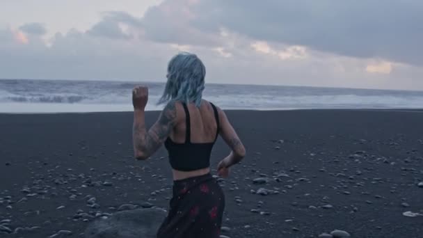 Cool Girl corriendo en la playa negra — Vídeo de stock