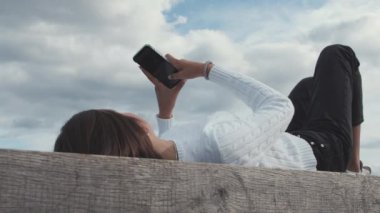 Beyaz kazaklı kadın Kopenhag Limanı 'nda telefon çalıyor.