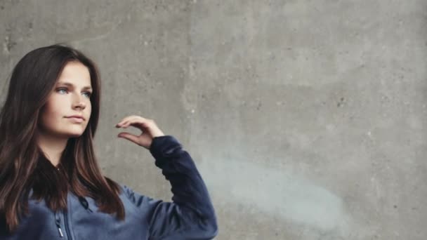 Charmant adolescent modèle mettre sur sweat à capuche et fixer son cheveux debout à l'extérieur — Video