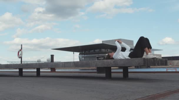 Wanita dengan Knees Bent Lying Down oleh Beton Bench di Dock — Stok Video