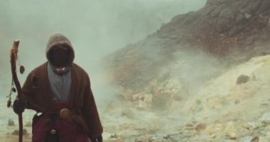 Puslu araziden geçen Kapüşonlu Adam