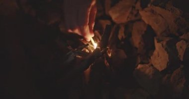 Yakacak odun yığınında el tutuşan kibrit.